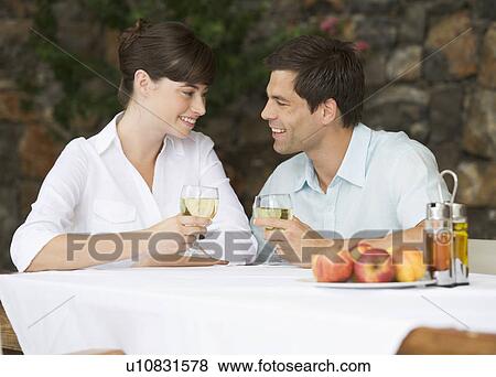 A couple sharing a bottle of wine at a table View Large Photo Image Stock Photo - A couple sharing a bottle of wine at a table. Fotosearch