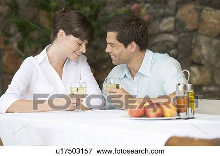 A couple sharing a bottle of wine at a table View Large Photo Image Stock Photo - A couple sharing a bottle of wine at a table. Fotosearch