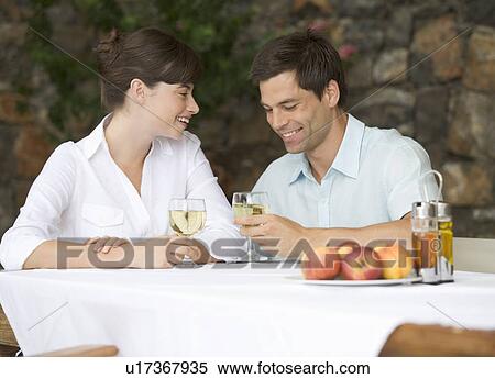 Stock Photography - A couple sharing a bottle of wine at a table. Fotosearch