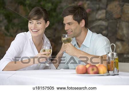 A couple sharing a bottle of wine at a table View Large Photo Image Stock Photography - A couple sharing a bottle of wine at a table. Fotosearch