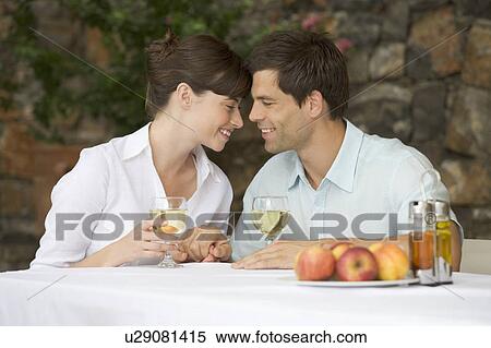 A couple sharing a bottle of wine at a table View Large Photo Image Stock Photography - A couple sharing a bottle of wine at a table. Fotosearch