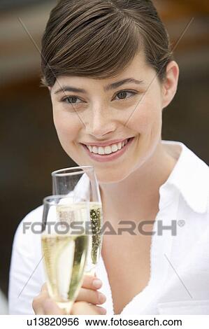 Stock Photograph - A woman drinking a glass of champagne. Fotosearch