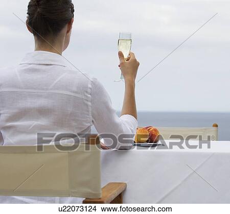 Picture - A woman drinking champagne alone. Fotosearch