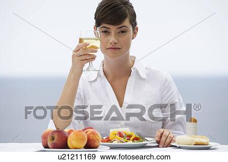 A woman eating alone View Large Photo Image Stock Photo - A woman eating alone. Fotosearch