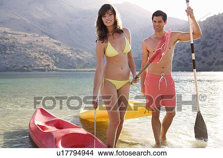 Picture - A couple canoeing on a lake. Fotosearch