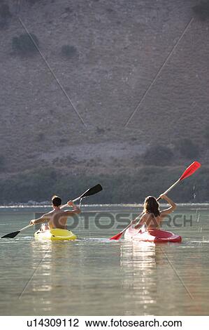 A couple canoeing on a lake View Large Photo Image Stock Image - A couple canoeing on a lake. Fotosearch