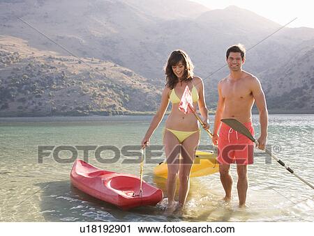 A couple canoeing on a lake View Large Photo Image Stock Image - A couple canoeing on a lake. Fotosearch
