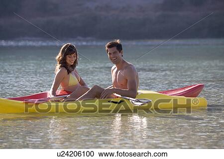 A couple canoeing on a lake View Large Photo Image Stock Image - A couple canoeing on a lake. Fotosearch
