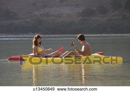 A couple canoeing on a lake View Large Photo Image Stock Photo - A couple canoeing on a lake. Fotosearch