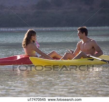 A couple canoeing on a lake View Large Photo Image Stock Photography - A couple canoeing on a lake. Fotosearch