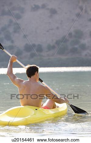 A man canoeing on a lake View Large Photo Image Stock Image - A man canoeing on a lake. Fotosearch