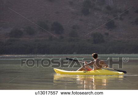 A man canoeing on a lake View Large Photo Image Stock Photo - A man canoeing on a lake. Fotosearch
