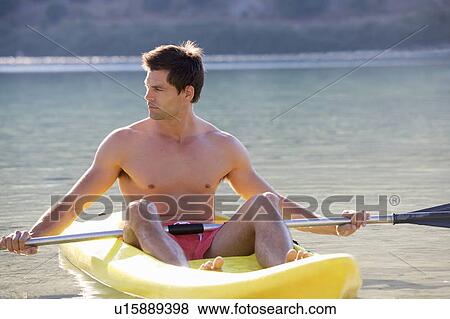 A man canoeing on a lake View Large Photo Image Stock Photo - A man canoeing on a lake. Fotosearch