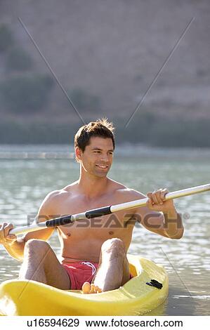 A man canoeing on a lake View Large Photo Image Stock Photo - A man canoeing on a lake. Fotosearch