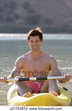 Stock Photography - A man canoeing on a lake. Fotosearch