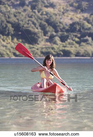 A woman canoeing on a lake View Large Photo Image Stock Image - A woman canoeing on a lake. Fotosearch