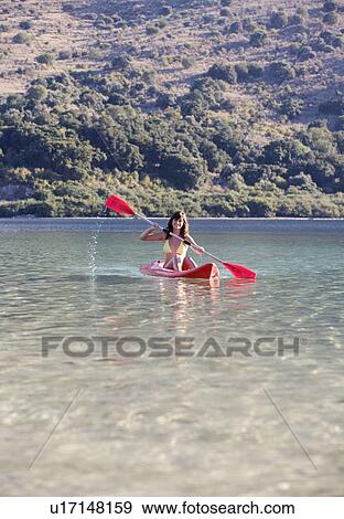 A woman canoeing on a lake View Large Photo Image Stock Photo - A woman canoeing on a lake. Fotosearch