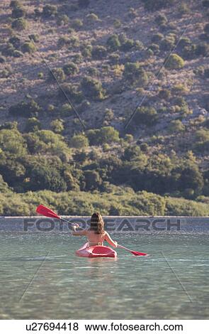 A woman canoeing on a lake View Large Photo Image Stock Photo - A woman canoeing on a lake. Fotosearch