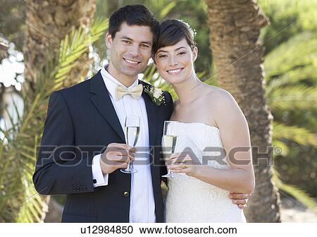 Stock Image - A bride and groom drinking champagne. Fotosearch