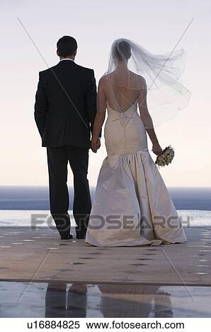 A bride and groom holding hands View Large Photo Image Stock Photography - A bride and groom holding hands. Fotosearch