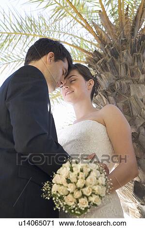 Stock Image - A bride and groom kissing. Fotosearch
