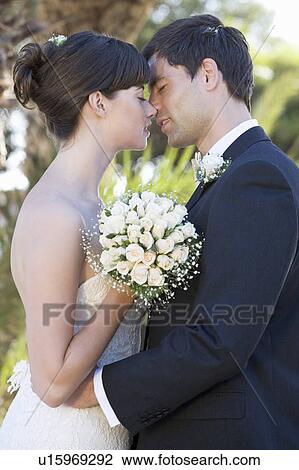 Stock Image - A bride and groom kissing. Fotosearch
