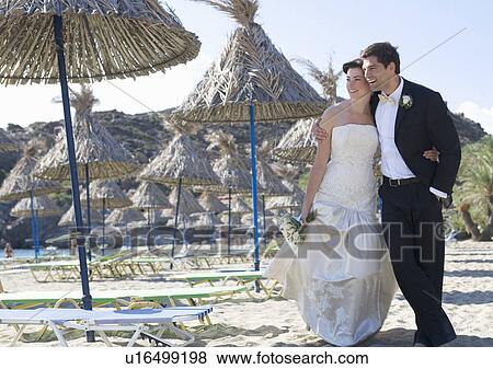 A bride and groom walking on a beach View Large Photo Image Stock Photo - A bride and groom walking on a beach. Fotosearch