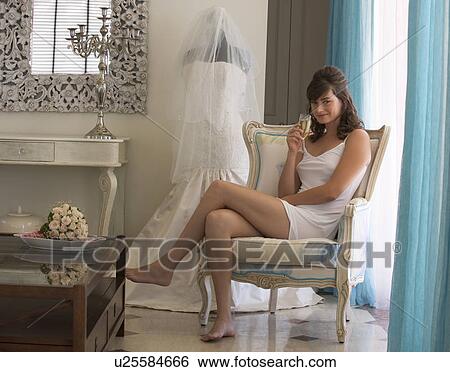 A bride drinking champagne in a room View Large Photo Image Stock Photograph - A bride drinking champagne in a room. Fotosearch