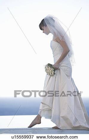 Stock Photo - A bride walking barefoot. Fotosearch