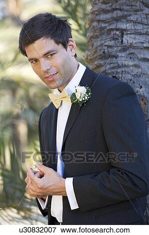 A groom holding the wedding ring View Large Photo Image Stock Photo - A groom holding the wedding ring. Fotosearch