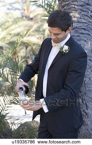 A groom pouring a glass of champagne View Large Photo Image Stock Photograph - A groom pouring a glass of champagne. Fotosearch