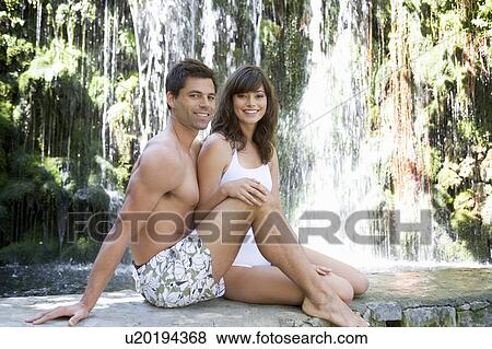 A couple sitting by a waterfall View Large Photo Image Stock Photo - A couple sitting by a waterfall. Fotosearch