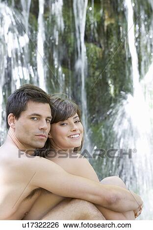 A couple sitting by a waterfall View Large Photo Image Stock Photograph - A couple sitting by a waterfall. Fotosearch