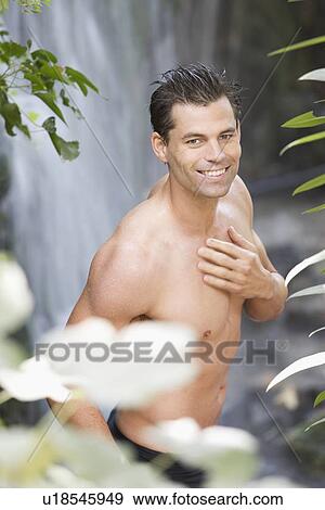 A man standing in a waterfall View Large Photo Image Stock Photo - A man standing in a waterfall. Fotosearch