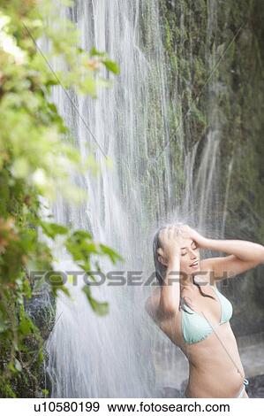 A woman standing in a waterfall View Large Photo Image Stock Photo - A woman standing in a waterfall. Fotosearch