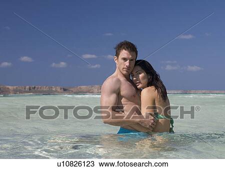 Stock Image - A couple standing in the sea. Fotosearch