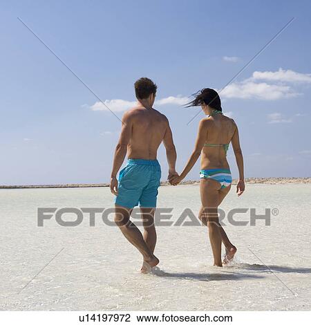 A couple walking on a beach View Large Photo Image Stock Image - A couple walking on a beach. Fotosearch