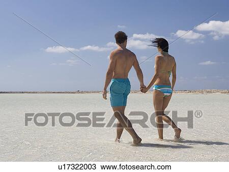 A couple walking on a beach View Large Photo Image Stock Image - A couple walking on a beach. Fotosearch
