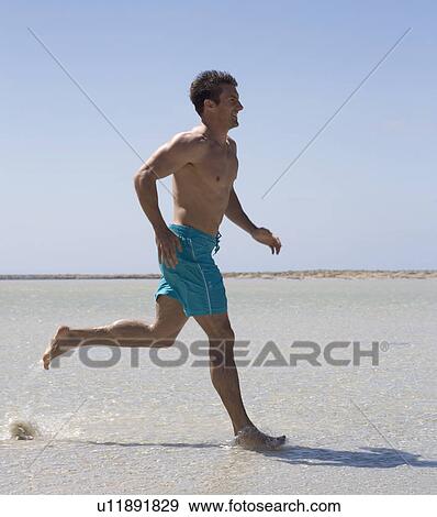 A man running on a beach View Large Photo Image Stock Photo - A man running on a beach. Fotosearch