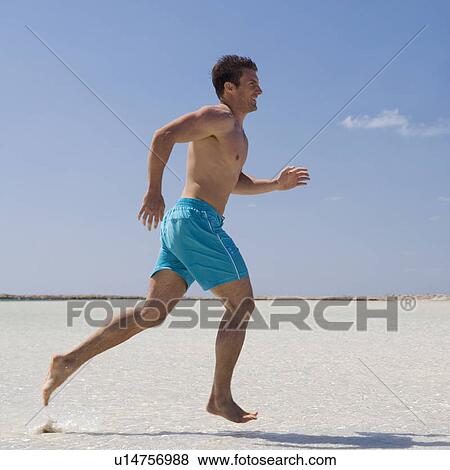 A man running on a beach View Large Photo Image Stock Photo - A man running on a beach. Fotosearch