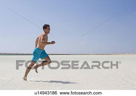 A man running on a beach View Large Photo Image Stock Photograph - A man running on a beach. Fotosearch