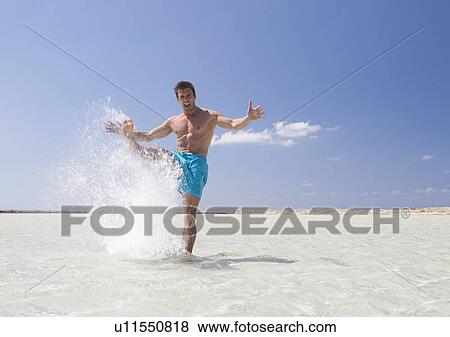 Stock Photo - A man splashing in the sea. Fotosearch