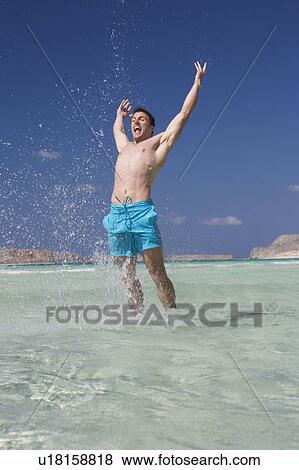 Stock Photo - A man standing in the sea. Fotosearch