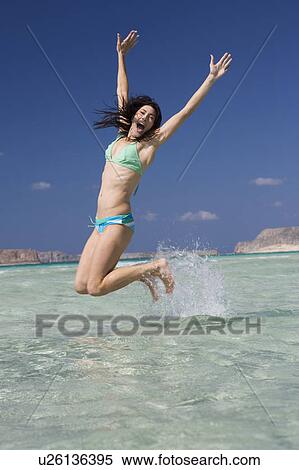 A woman jumping in the sea View Large Photo Image Stock Photography - A woman jumping in the sea. Fotosearch