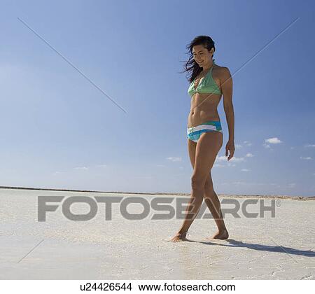 A woman walking on a beach View Large Photo Image Picture - A woman walking on a beach. Fotosearch