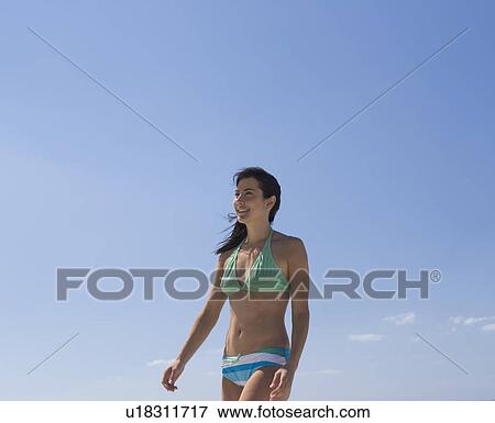 A woman walking on a beach View Large Photo Image Stock Photo - A woman walking on a beach. Fotosearch