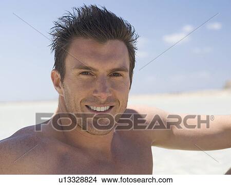 Picture - Portrait of a man sitting on a beach. Fotosearch