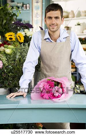 Male florist with bouquet of flowers at the shop counter View Large Photo Image Stock Image - Male florist with bouquet of flowers at the shop counter. Fotosearch