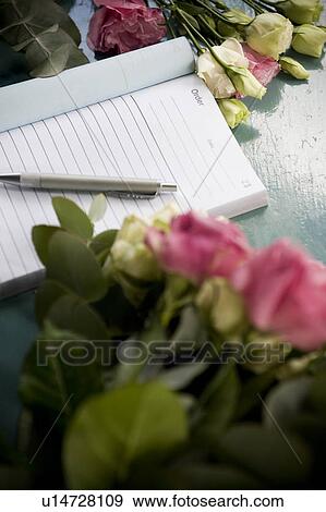 Stock Photo - Order book and pen lying on the counter of a florist's shop. Fotosearch