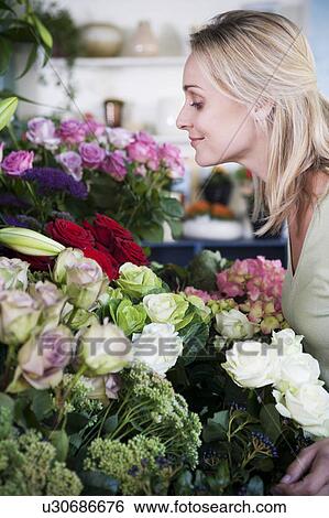 Stock Photograph - Woman choosing flowers in a florist's shop. Fotosearch